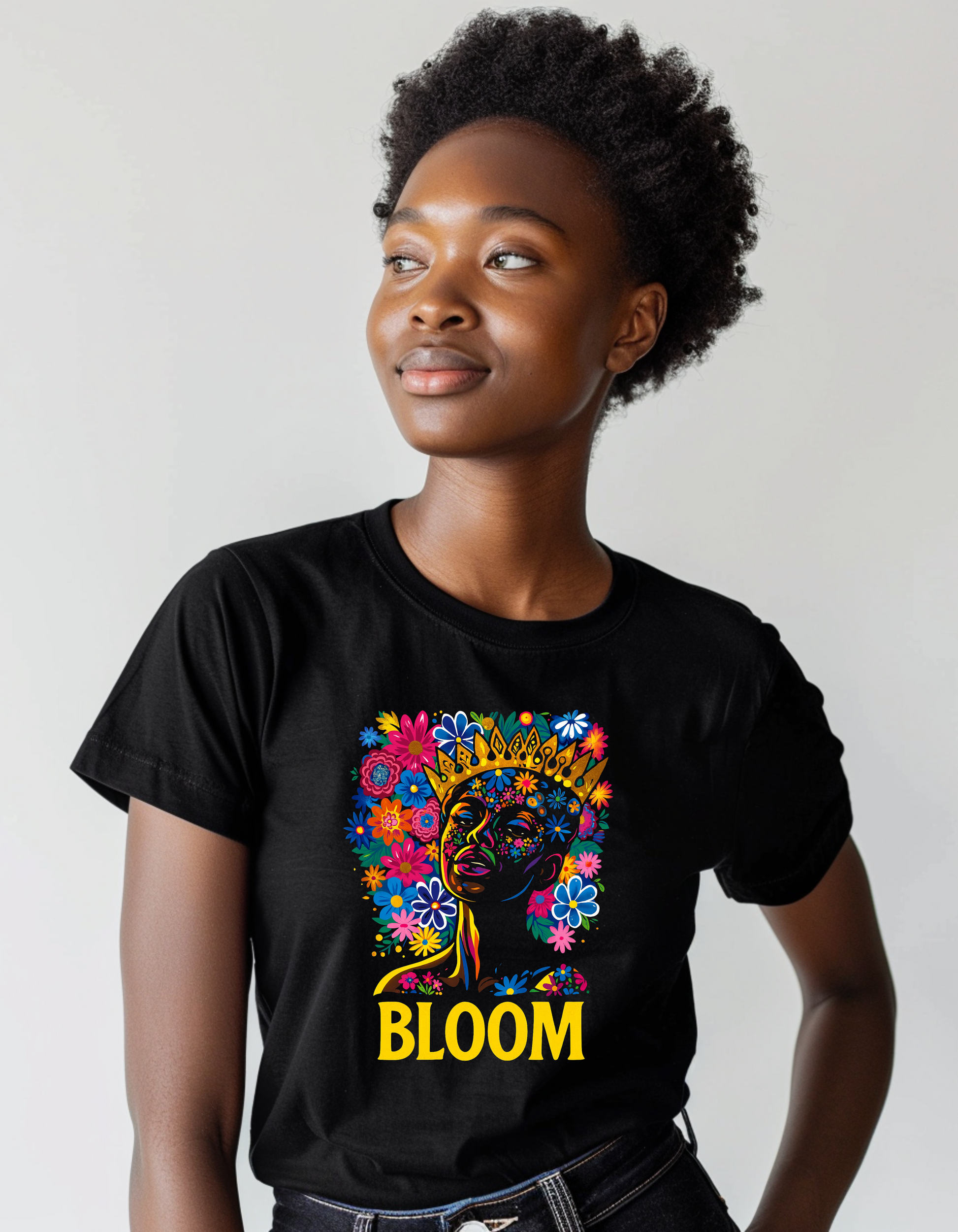 Person wearing a black t-shirt with a colorful graphic and the word 'BLOOM' on a plain background